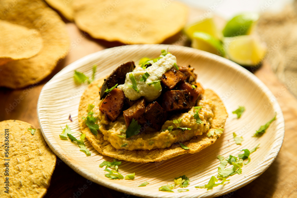 Tostada with hummus and vegetables. Tostada, name given to various dishes in Mexico that include a toasted tortilla as the main base of its preparation. Tostada with hummus and vegetables. Tostada, name given to various dishes in Mexico that include a toasted tortilla as the main base of its preparation.