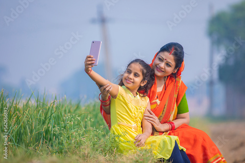 Slika na platnu Indian little girl taking selfie with mother at agriculture field