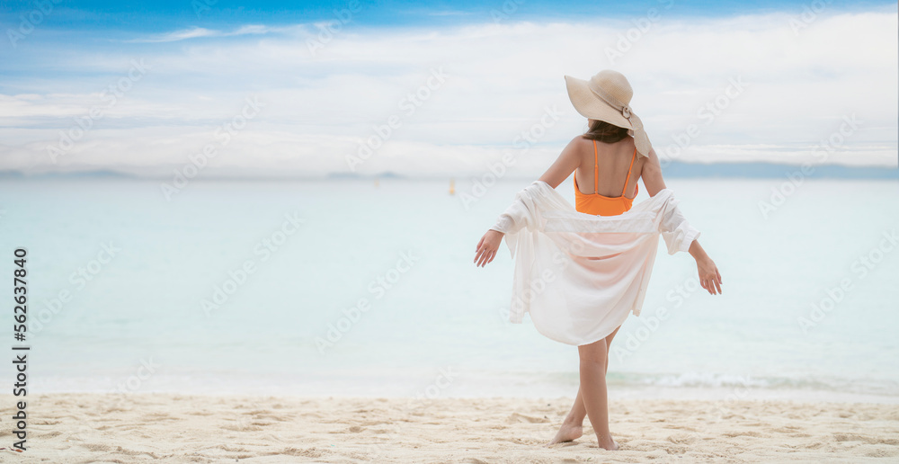 Asian tourist woman in orange bikini on the beach Asian tourist woman in orange bikini on the beach