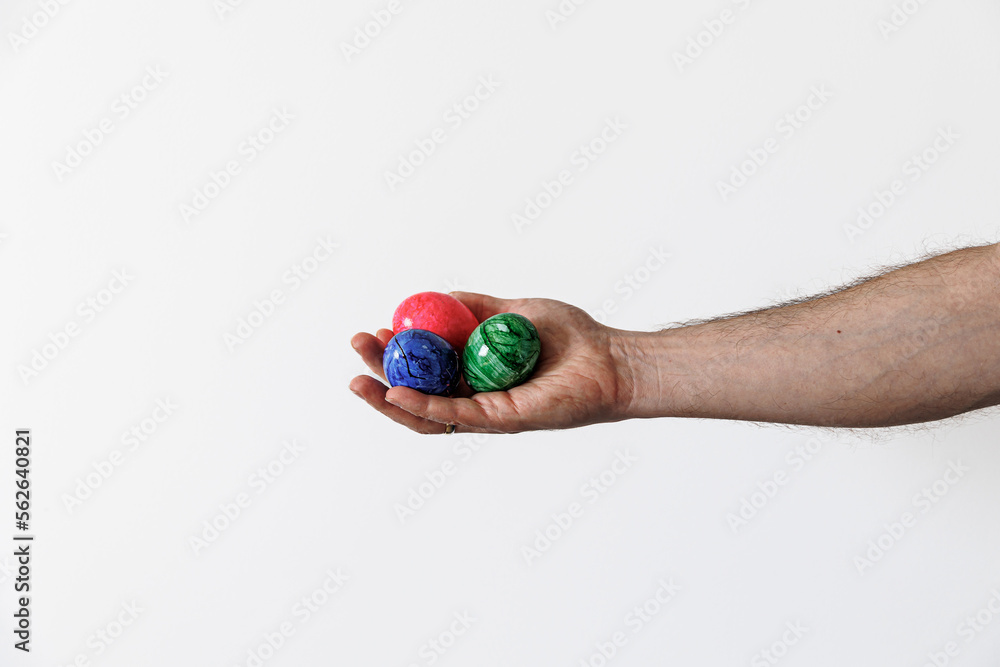 colored easter eggs in a male hand on a light background colored easter eggs in a male hand on a light background
