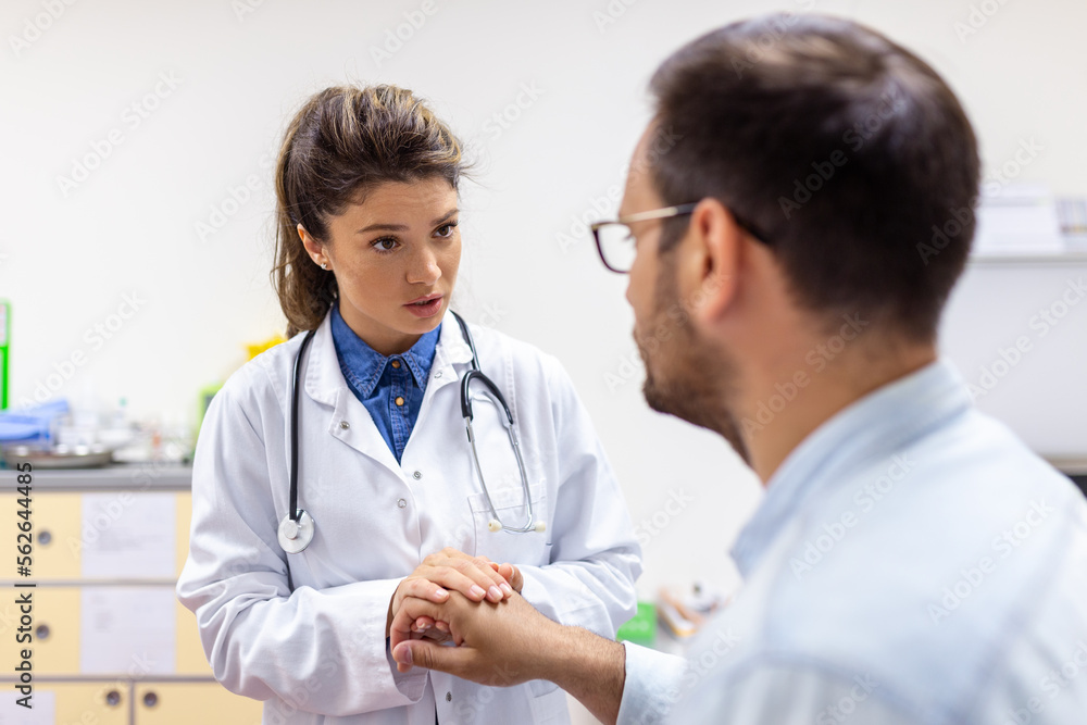 Young female doctor hold hand of caucasian man patient give comfort, express health care sympathy, medical help trust support encourage reassure infertile patient at medical visit Young female doctor hold hand of caucasian man patient give comfort, express health care sympathy, medical help trust support encourage reassure infertile patient at medical visit