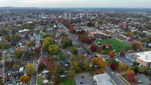 Slow high aerial orbit showing skyline and outskirts of small city in America during autumn. Changing leaves during fall and beautiful cityscape. photo