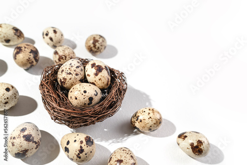 Quail eggs on a white background.  Nest containing three egg. Minimal Easter concept. Natural farm products