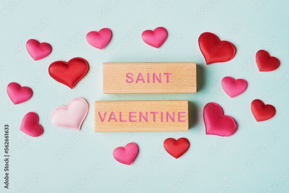 Valentines hearts and wooden blocks with words Saint Valentine. Valentine’s day greeting concept