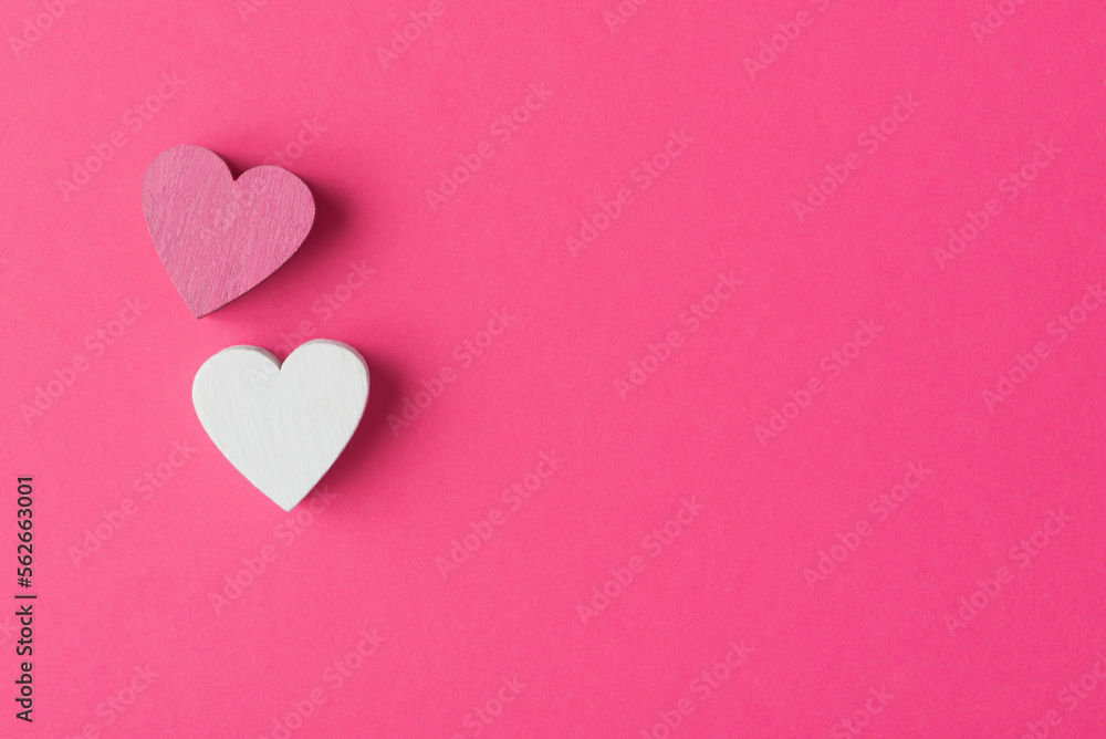 Two Valentine’s hearts on pink background with copy space