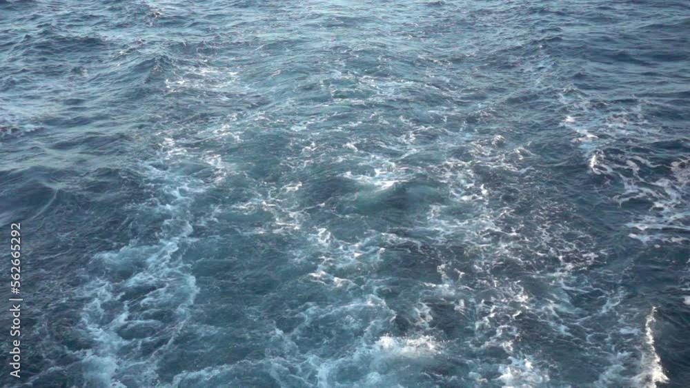 Wake of vessel. Wide wake trail from boat. Back view. Ocean water. Deep blue. Trace from large ship. Wake of vessel. Wide wake trail from boat. Back view. Ocean water. Deep blue. Trace from large ship.