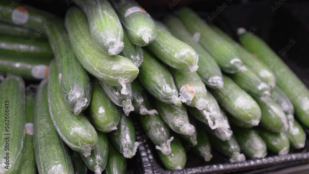 Vidéo Stock Plastic cucumbers on display at a grocery store. Cucumbers