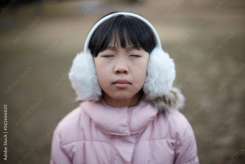 寒い公園にいる小学生の女の子の顔写真 寒い公園にいる小学生の女の子の顔写真