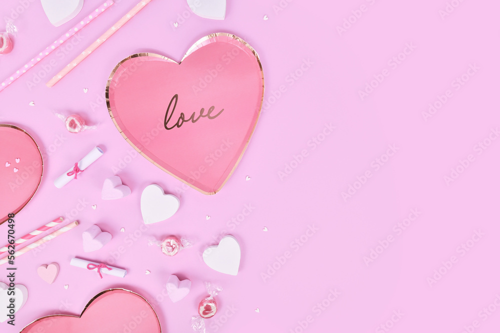Pastel colored Valentine's Day flat lay with heart shaped plates, heart ornaments and candy on violet background Pastel colored Valentine's Day flat lay with heart shaped plates, heart ornaments and candy on violet background