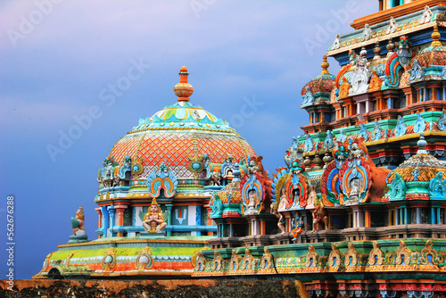 Beautiful view of colorful gopura and cupola in the Hindu Jambukeswarar Temple against the background of cloudy blue sky in Srirangam island, Trichy (Tiruchirappalli, Tiruchi), Tamil Nadu, South India