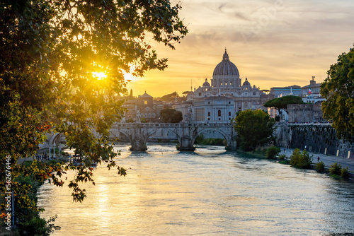 St. Peter's basilica dome and St. Angel bridge over Tiber river at sunset in Rome, Italy