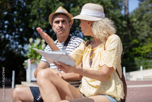 upset couple sitting on bench in the park