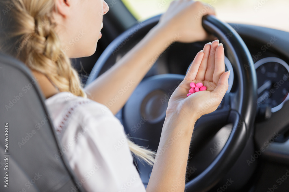 woman holds tablets at the steering wheel while driving