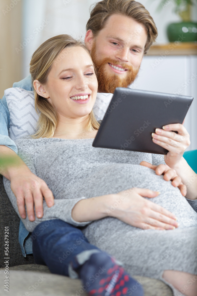 happy couple holding a tablet