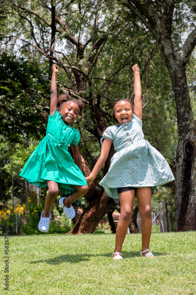 Fototapeta premium African girls jumping and shouting in garden.