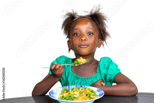 Cute little african kid eating a mixed vegetable dish