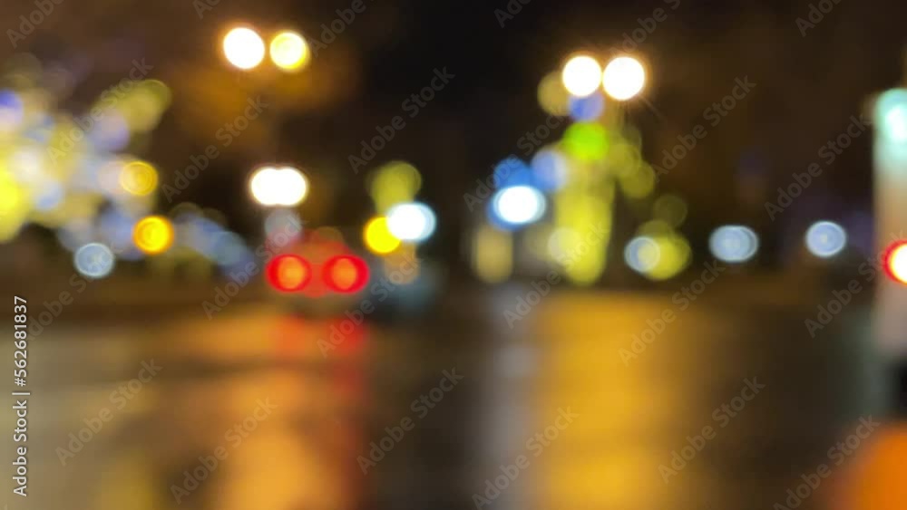 Blurred car lights bokeh in the evening city. Defocused headlights and street lighting at night. Moving bokeh circles of cars at night. Blurred city traffic background