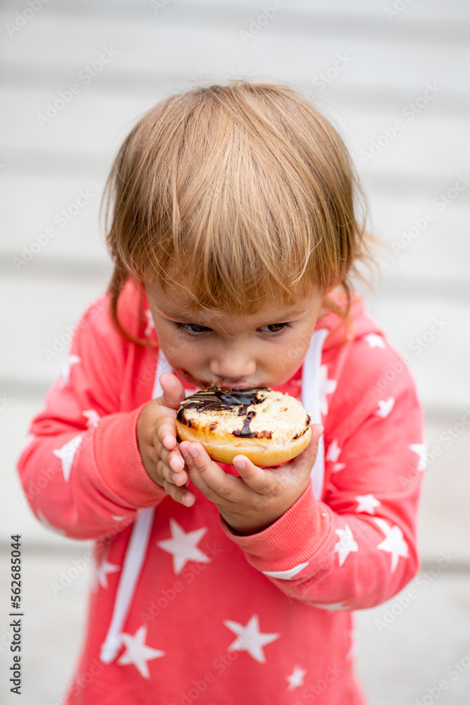 icing-stained girl eating donut icing-stained girl eating donut