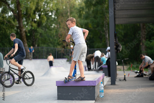 boy exercising on a scooter in a skatepark