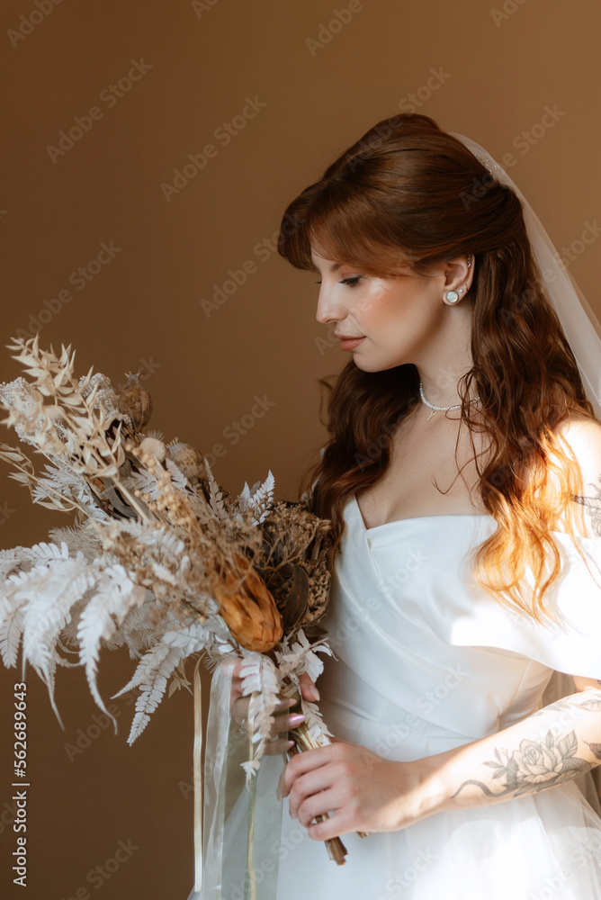 portrait of a bride girl with red hair in a white wedding dress