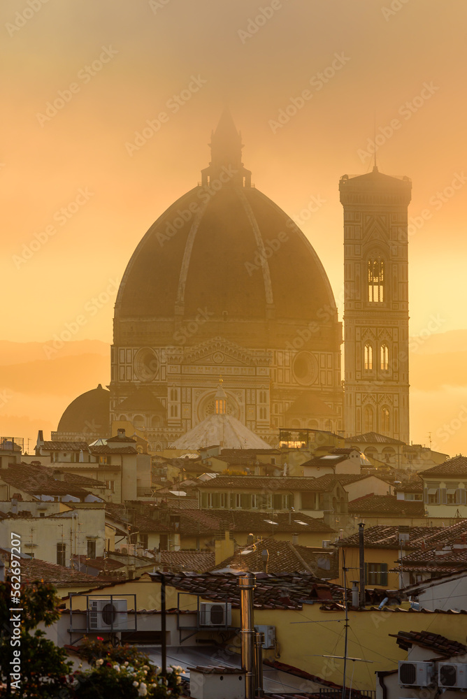Obraz premium The Florence Cathedral in a golden misty sunrise early morning.