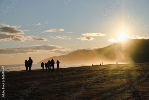 People walking along the beach at sunset in Castelldefels Spain