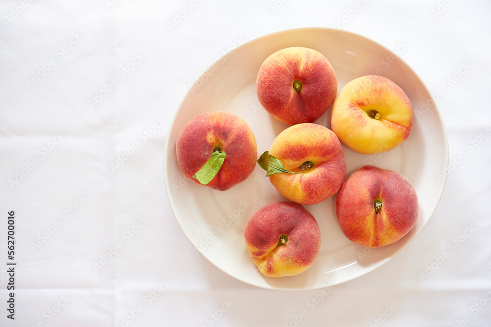 Overhead view of peaches in plate over white background Overhead view of peaches in plate over white background