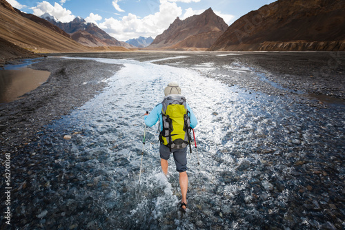 A woman is hiking in a stream bed, Spiti, India. photo