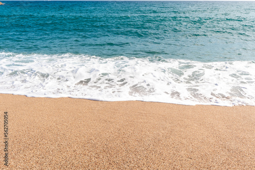 Photo Paisaje marino de la costa brava con la imagen de la playa con la espuma de las olas finalizando en la arena