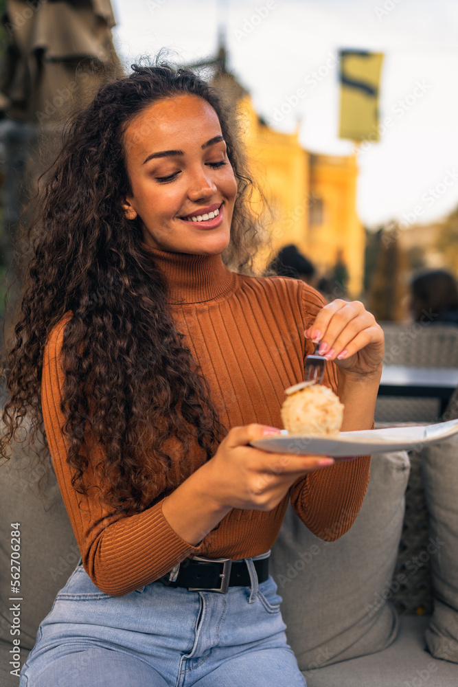 A beautiful girl with curly hair is eating delicious ice cream with chocolate flavor. A beautiful girl with curly hair is eating delicious ice cream with chocolate flavor.