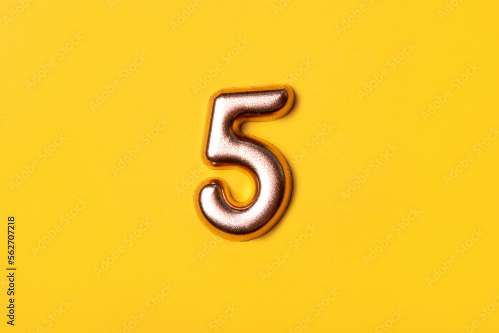 Naklejka premium Metal number five on a yellow background. Top view.