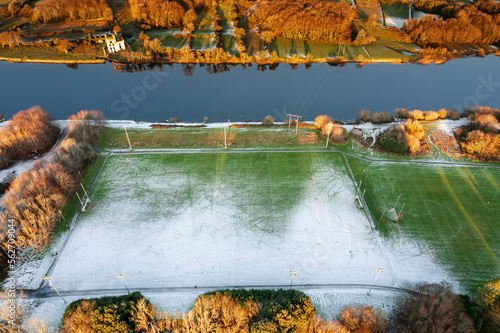 Field with tall goal post for Irish national sport rugby, hurling, camogie and Gaelic football covered with snow. Cold winter season. Training ground area. photo