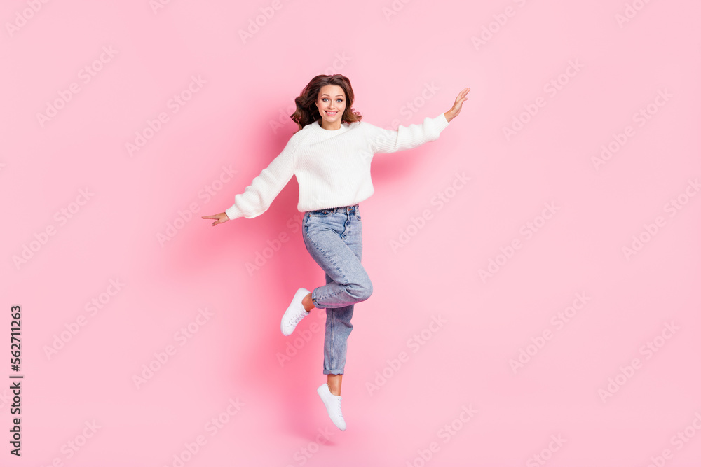 Full length photo of sweet pretty lady wear white sweater jumping high smiling isolated pink color background