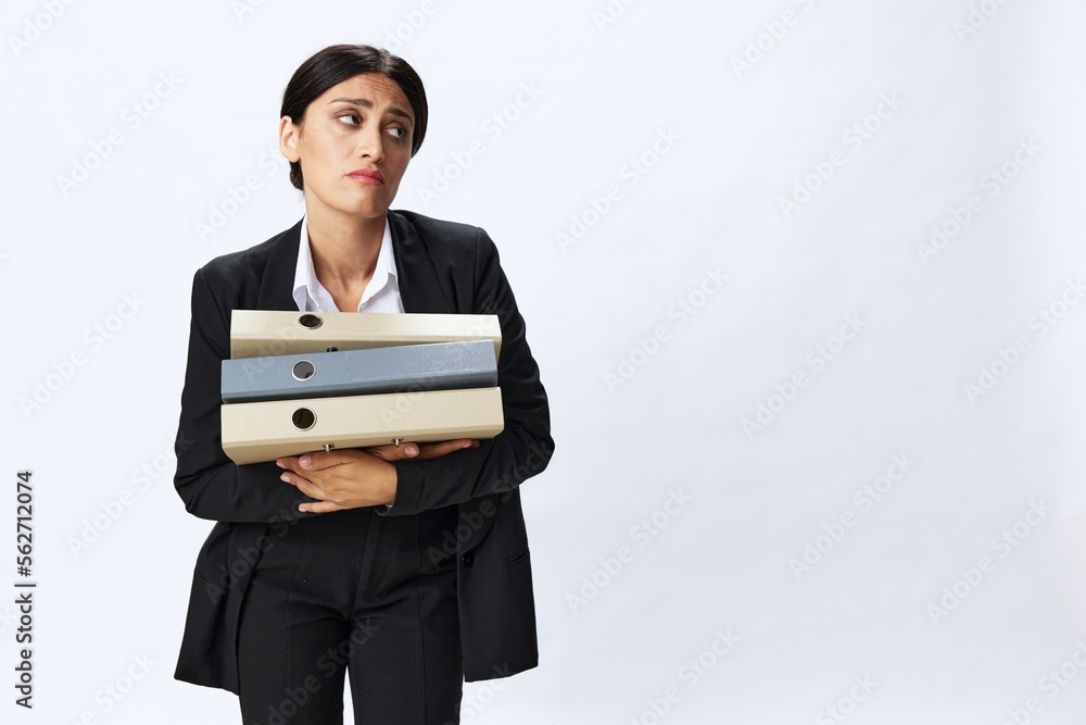 Business woman with a folder of documents in her hands in a black business suit and glasses shows signals gestures and emotions on a white background, work freelancer online training Business woman with a folder of documents in her hands in a black business suit and glasses shows signals gestures and emotions on a white background, work freelancer online training