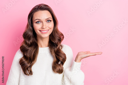 Photo of cute cheerful person toothy smile arm palm hold empty space offer isolated on pink color background