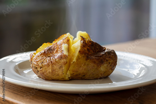 Hot baked potato with crispy skin and melted butter
