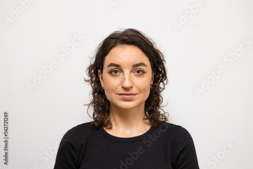 A beautiful woman on a white background looks directly into the camera 