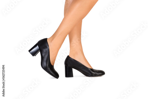Piernas de mujer con zapatos negros sobre un fondo blanco liso y aislado. Vista de frente y de cerca. Copy space