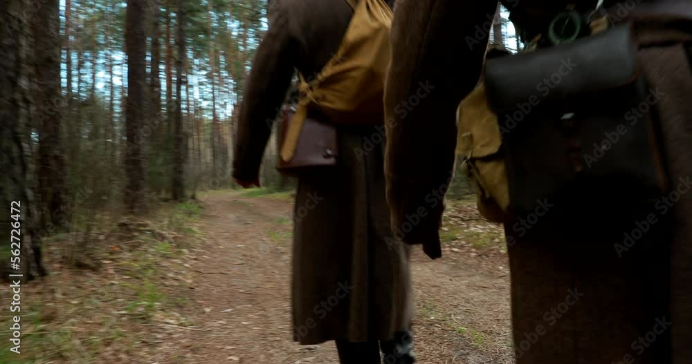 Camera flying very low over ground and followed for Squad Men Dressed As World War II Russian Soviet Red Army Soldiers Marching Through Spring Forest In Sunny day. Soldier Of WWII WW2 Times. Camera flying very low over ground and followed for Squad Men Dressed As World War II Russian Soviet Red Army Soldiers Marching Through Spring Forest In Sunny day. Soldier Of WWII WW2 Times.