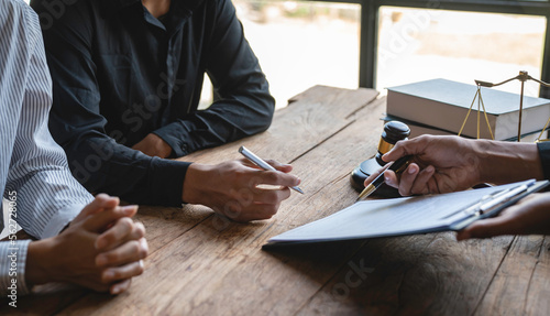 A young Asian lawyer or legal advisor clarifies information about business deals. Investment contract for the two businessmen who are listening and singing together.