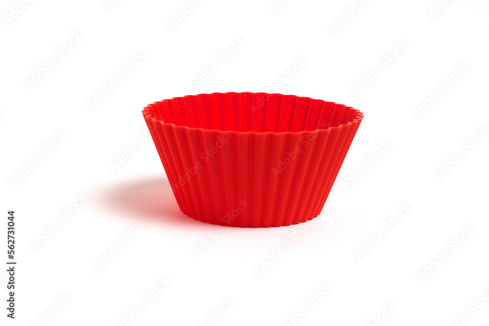 A red silicone mold for baking a cupcake on a white background