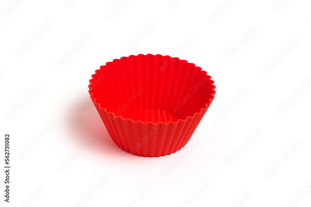A red silicone mold for baking a cupcake on a white background A red silicone mold for baking a cupcake on a white background