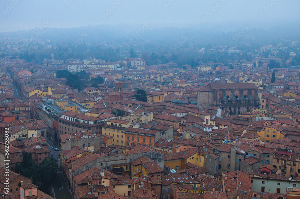 Scenic bird-eye view from the top of the tower on Bologna old town center. Vintage buildings with red tile roofs. Famous touristic place and travel destination in Europe. UNESCO World Heritage Site