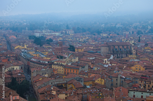 Scenic bird-eye view from the top of the tower on Bologna old town center. Vintage buildings with red tile roofs. Famous touristic place and travel destination in Europe. UNESCO World Heritage Site