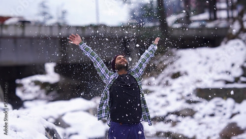 Indian boy enjoying and playing with snow during winter snowfall