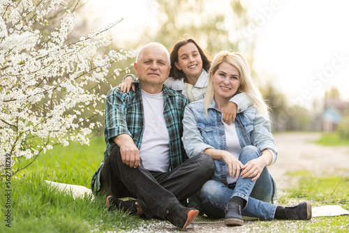 Three generation family sitting outside in spring nature photo