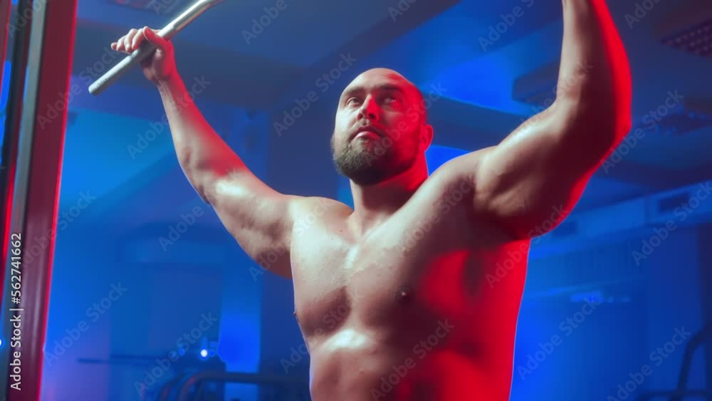 Bodybuilder with pumped muscles is performing technique of upper block ...