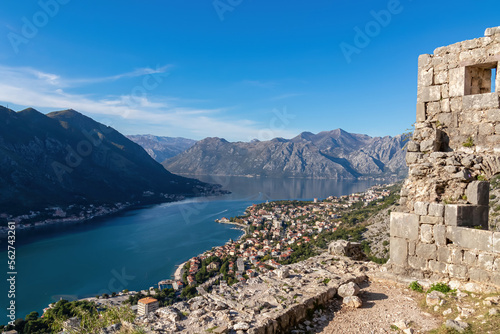 Panoramic view from Kotor city walls on Kotor bay in sunny summer, Adriatic Mediterranean Sea, Montenegro, Balkan Peninsula, Europe. Fjord winding along coastal town Dobrota. Lovcen, Orjen mountains photo