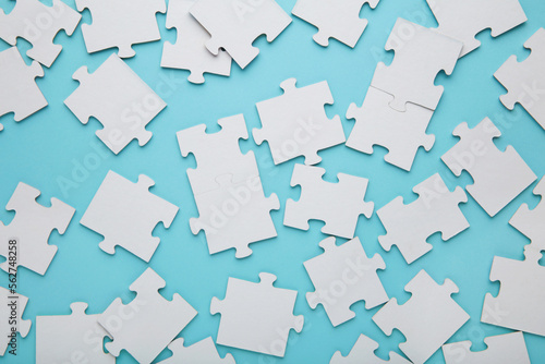 Close-up of a pile of uncompleted elements of a white puzzle. A huge number of rectangular pieces from one large white mosaic