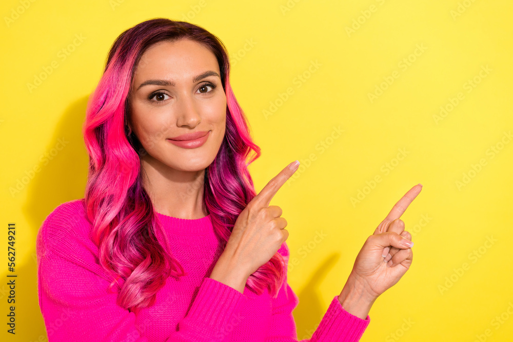 Photo of funky shiny girl dressed vibrant pullover pointing two fingers empty space isolated yellow color background